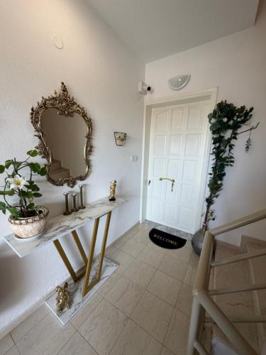a room with a table with a mirror and a door at Elenas Apartments in Plataria