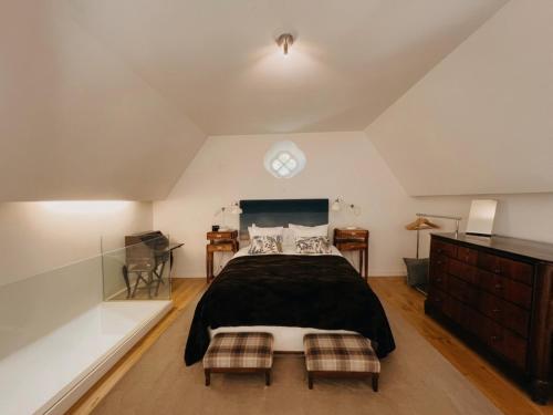 a bedroom with a bed and a clock on the wall at A Capela - A Essência de Sintra in Sintra