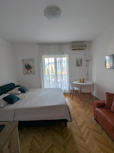 a bedroom with a large bed and a living room at Azzurro in Igalo
