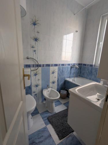 a bathroom with a toilet and a tub and a sink at Azzurro in Igalo