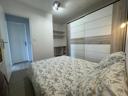 a small bedroom with a bed and a closet at logement de charme vue mer in Binic