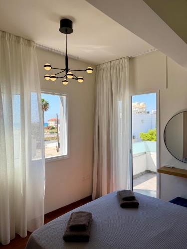 a bedroom with a bed and a large window at Relax Beach Apartment in Larnaca