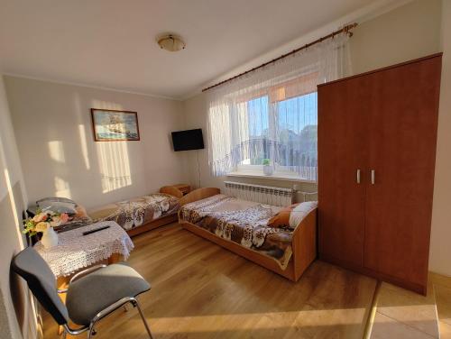 a bedroom with two beds and a window at Agroturystyka Biedrzycki in Nowe Guty