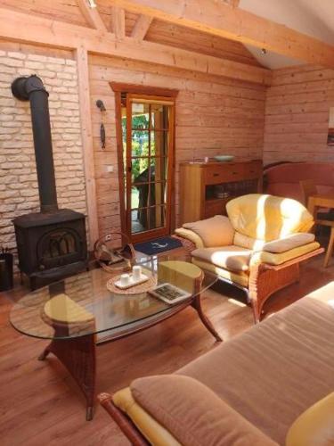 a living room with a fireplace in a log cabin at Klimatyczny domek z drewna nad morzem in Debina
