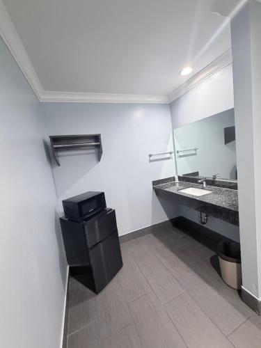 a bathroom with a sink and a mirror at Coronado Motel in Long Beach