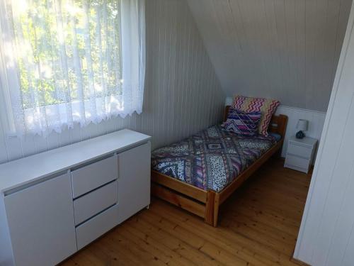 a small bedroom with a bed and a window at DOMEK SASINO in Sasino