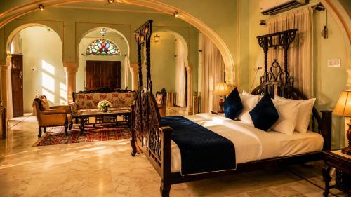 a bedroom with a large bed in a room at Pachewar Garh - A Heritage Fort in Pachhewar