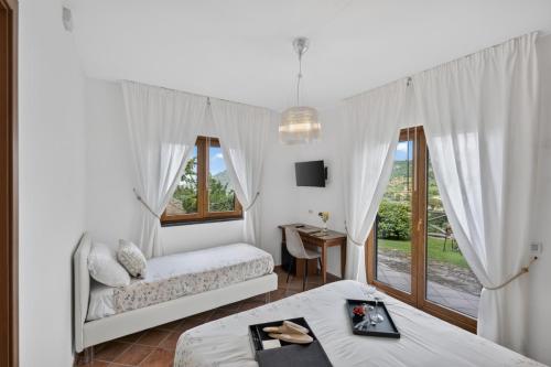 a white bedroom with two beds and a window at Villevieille in Piano di Sorrento