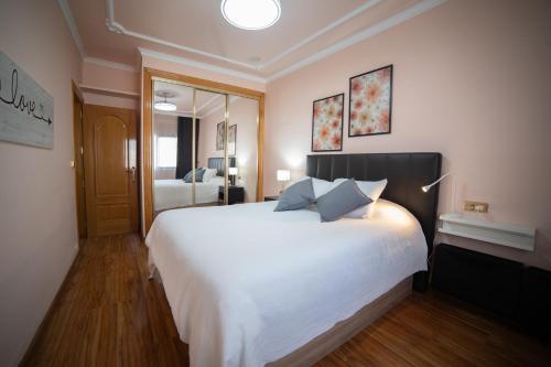 a bedroom with a large white bed with two pillows at Casa Alcazaba in Guadix