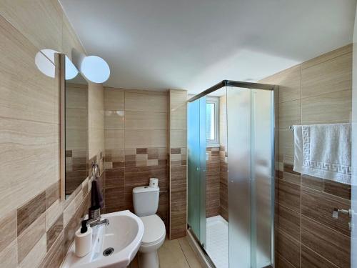 a bathroom with a toilet and a sink and a shower at Relax Beach Apartment in Larnaca