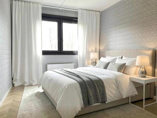 a bedroom with a large white bed and a window at Ediths hus in Pärup