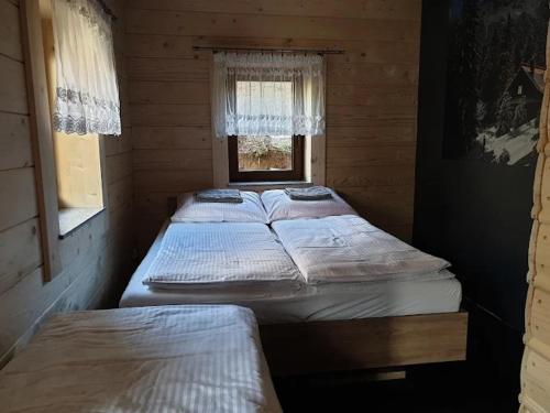 two beds in a small room with a window at Śleboda Home&Spa in Gliczarów Górny