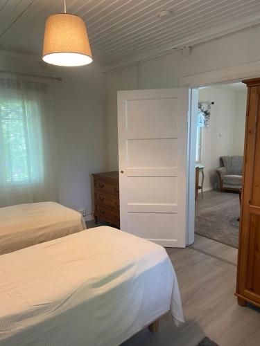 a bedroom with two beds and a sliding door at Villa Tapiola in Lohja