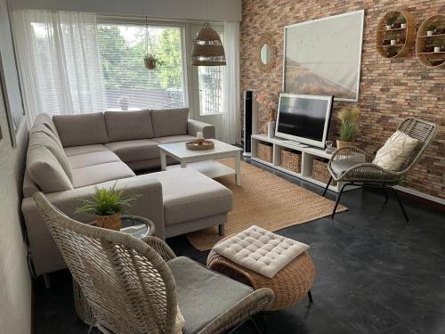 a living room with a couch and a tv at Yyterin Meriheinä in Pori