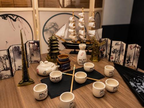 a table with cups and a miniature ship on it at Nau Guest House & Restaurant in Iquitos
