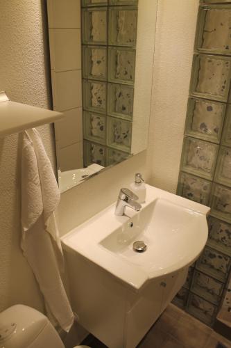 a bathroom with a sink and a mirror and a toilet at Odense Apartments in Odense