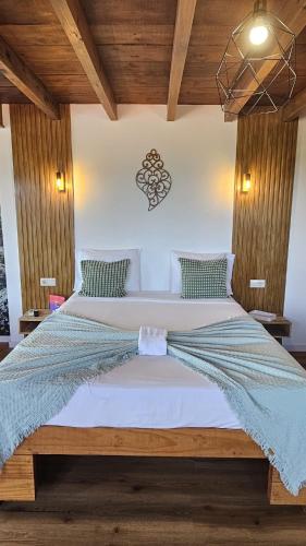 a large bed in a bedroom with wooden ceilings at Fernandes Guest House Green Bungalow in Ponte de Lima