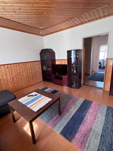 a living room with a coffee table and a refrigerator at Villa Puutarha, Merikarvia in Merikarvia