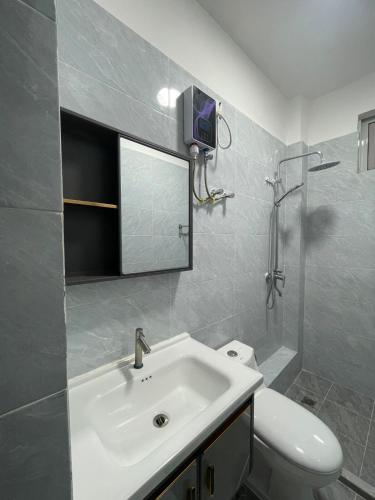 a bathroom with a white sink and a toilet at Cozy Nest in Marimbeti
