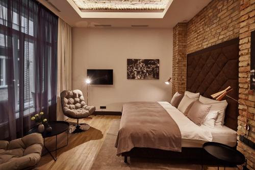 - une chambre avec un grand lit et un mur en briques dans l'établissement The Loft Budapest, à Budapest