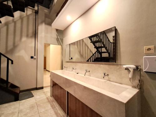 a bathroom with a large sink and a mirror at Nafaka Hostel and Tours in Malang