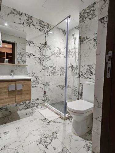 a bathroom with a shower and a toilet and a sink at Ocean Rooftop Hotel in Ben Slimane