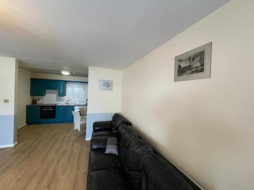 a living room with a black couch against a wall at Modern Town Centre 3 Bed Apartment in Sligo