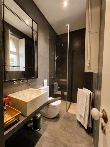 a bathroom with a sink and a toilet and a shower at A Capela - A Essência de Sintra in Sintra