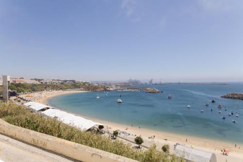 a beach with a bunch of people in the water at Manas Slowliving - Sines in Sines