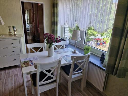a kitchen with a table and chairs and a window at Haus Schildt, FeWo 2 in Duhnen