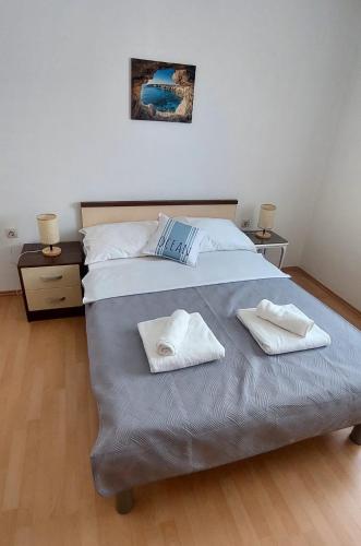 a bedroom with a large bed with two towels on it at Ruža Vacation House in Međugorje