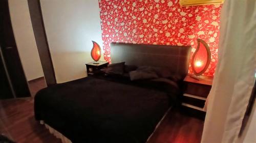 a bedroom with a bed with two lamps on it at Temporario balcarce in Santo Tomé