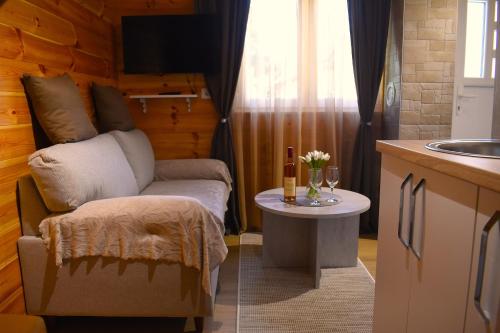 a kitchen with a couch and a table with a bottle of wine at Durmitorski san in Žabljak