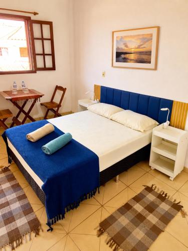 a large bed with a blue headboard in a room at Reis Family Paraty - Suíte Privativa Nova e Funcional com Varanda in Paraty