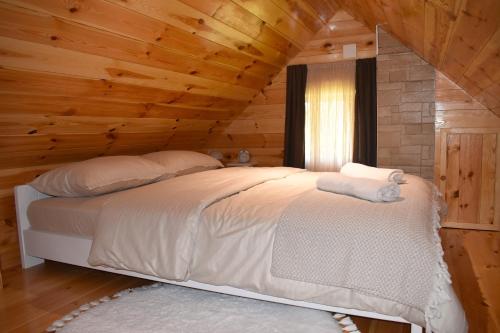 a bedroom with a bed in a log cabin at Durmitorski san in Žabljak