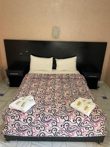 a large bed with two pillows on top of it at Hôtel Résidence Marrakech in Marrakesh