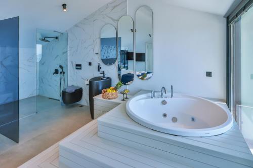 a bathroom with a large white tub and a shower at Villa Infinity Sky - Private Pool - Panoramic Sea View in Kaş