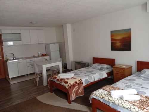 a hotel room with two beds and a kitchen at Guest house Erdan in Plav