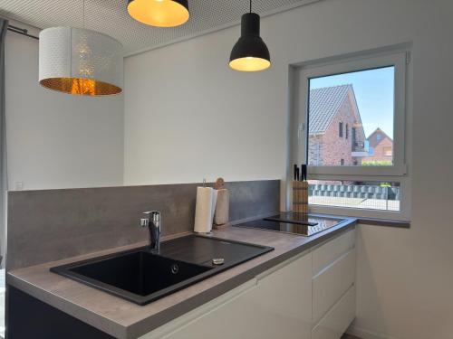 a kitchen with a sink and a window at Moderne Ferienwohnung mit Sauna & Terrasse in Burhave