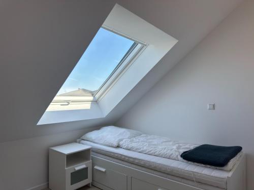 a bed in a room with a window at Moderne Ferienwohnung mit Sauna & Terrasse in Burhave