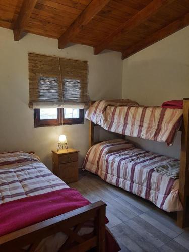 a bedroom with two bunk beds and a window at Tafi del Valle Casa Kabure in Tafí del Valle