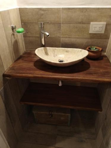 a white sink on a wooden counter in a bathroom at Tafi del Valle Casa Kabure in Tafí del Valle