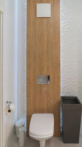 a bathroom with a white toilet and a wooden door at BEMO Apartment in Warsaw