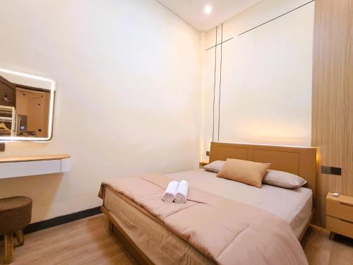 a bedroom with a bed with two white towels on it at Nafaka Hostel and Tours in Malang