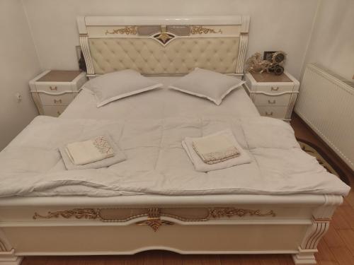 a large white bed with two pillows on it at Vila Elena in Bucharest