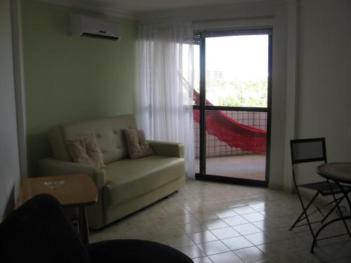 a living room with a couch and a sliding glass door at Victory Flat Intermares in Cabedelo