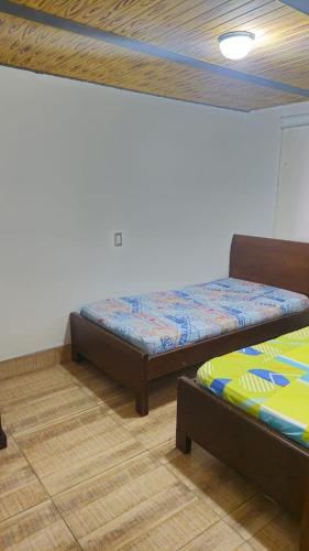 two beds in a room with wooden floors at Natural country house in Guarne