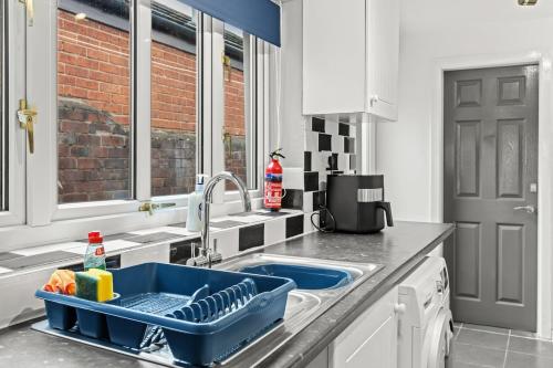 a kitchen with a sink with a blue dish drainer at Haydock Contractor House, 2-Bed, Easy M6 Access in Haydock