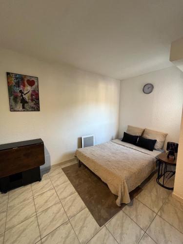 a bedroom with a bed and a television in it at Studio avec piscine à 1km de la plage in Cavalaire-sur-Mer