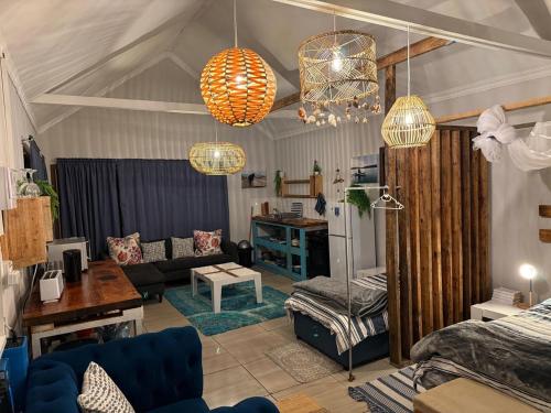 a living room with two chandeliers and a couch at Blue Lagoon 4x4 Cottage in Umngazana